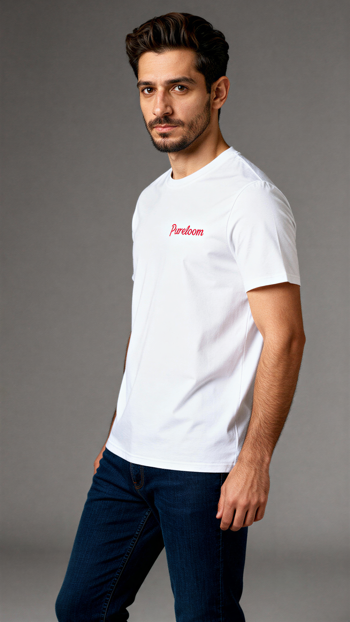 במבט צדדי, גבר לובש חולצת כותנה אורגנית לבנה עם לוגו אדום "Pureloom" בצד שמאל של החזה מבית פיורלום.