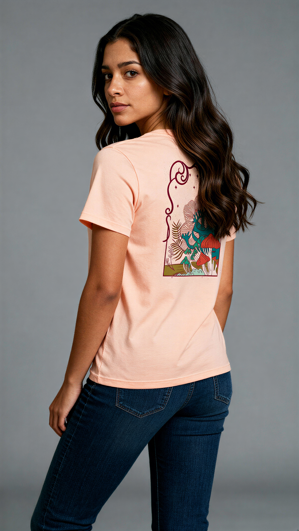 במבט מאחור, אישה לובשת חולצת כותנה אורגנית בצבע ורוד עם הדפס צבעוני של פטריות ועצים בעיצוב אמנותי מבית פיורלום.