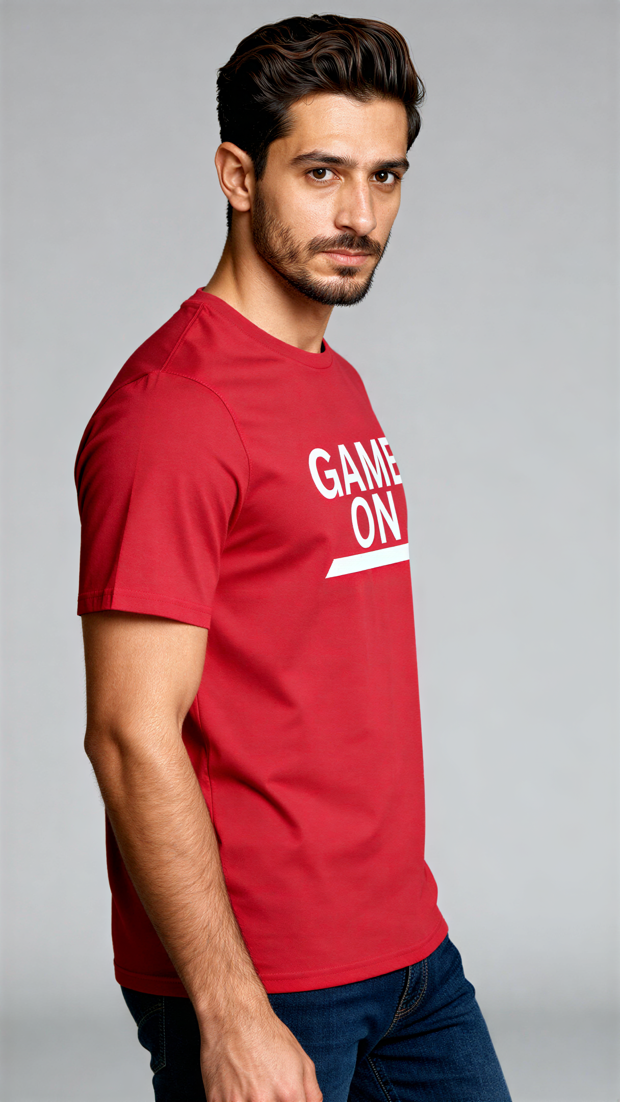 במבט צדדי, גבר לובש חולצת כותנה אורגנית אדומה עם כיתוב לבן "Game On" מבית פיורלום.