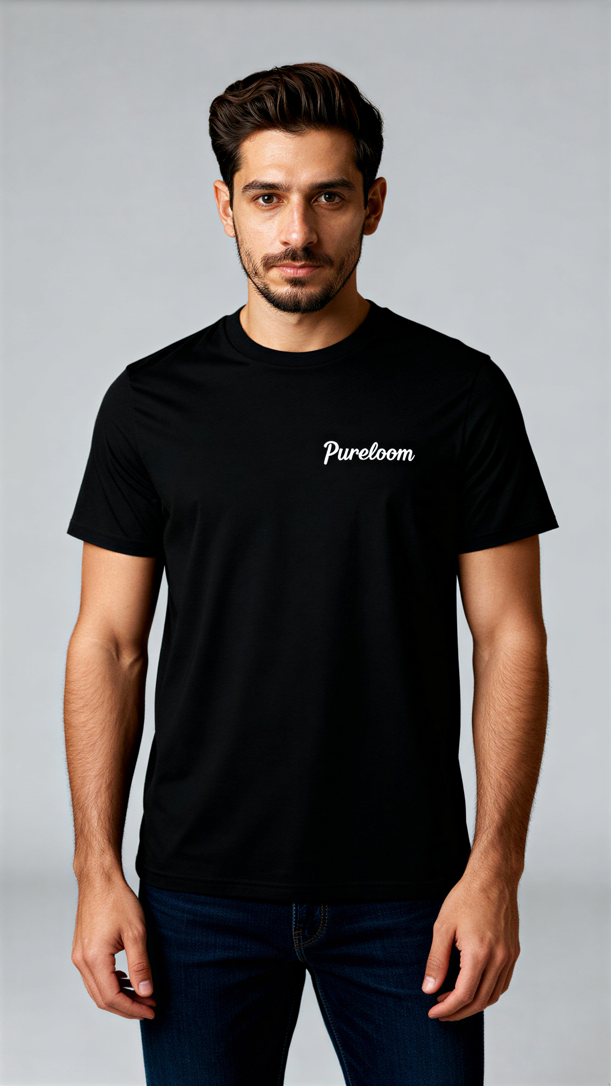 במבט קדמי, גבר לובש חולצת כותנה אורגנית שחורה עם לוגו לבן "Pureloom" בצד שמאל של החזה מבית פיורלום.