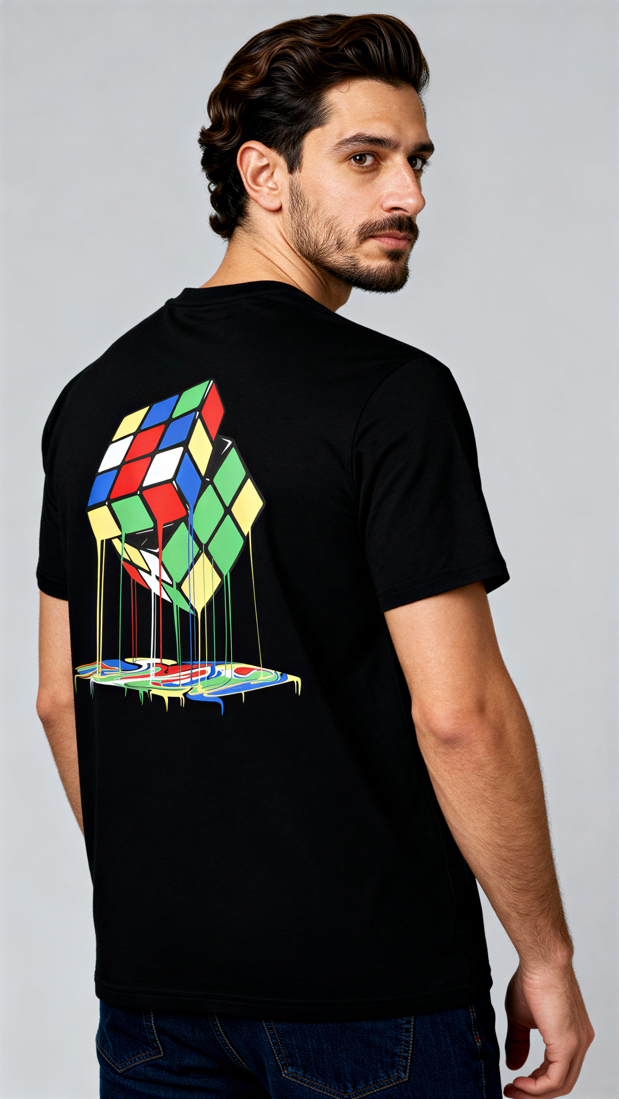 במבט מאחור, גבר לובש חולצת כותנה אורגנית שחורה עם הדפס צבעוני של קוביית רוביק נמסה מבית פיורלום.