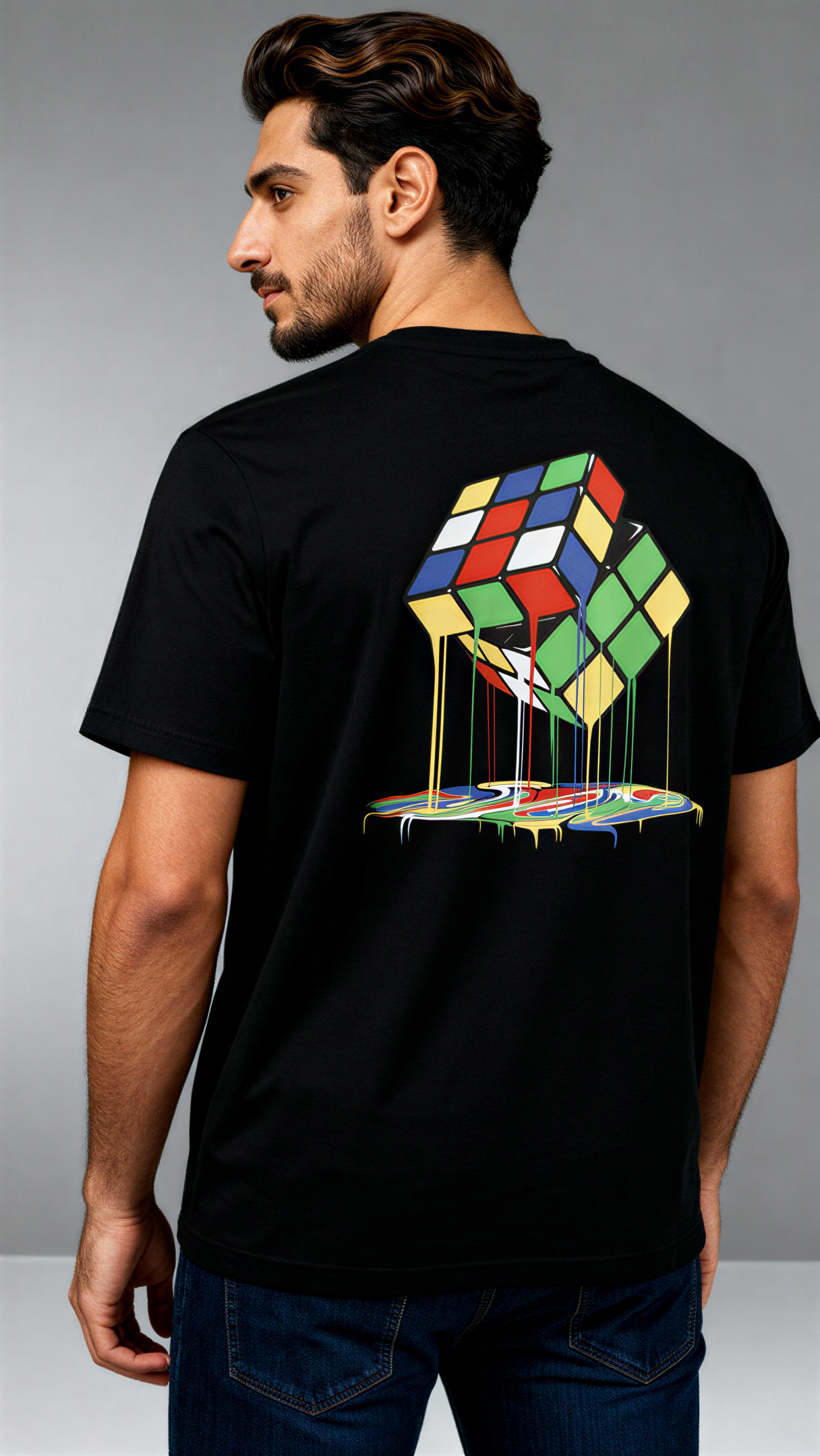 במבט מאחור, גבר לובש חולצת כותנה אורגנית שחורה עם הדפס צבעוני של קוביית רוביק נמסה מבית פיורלום.