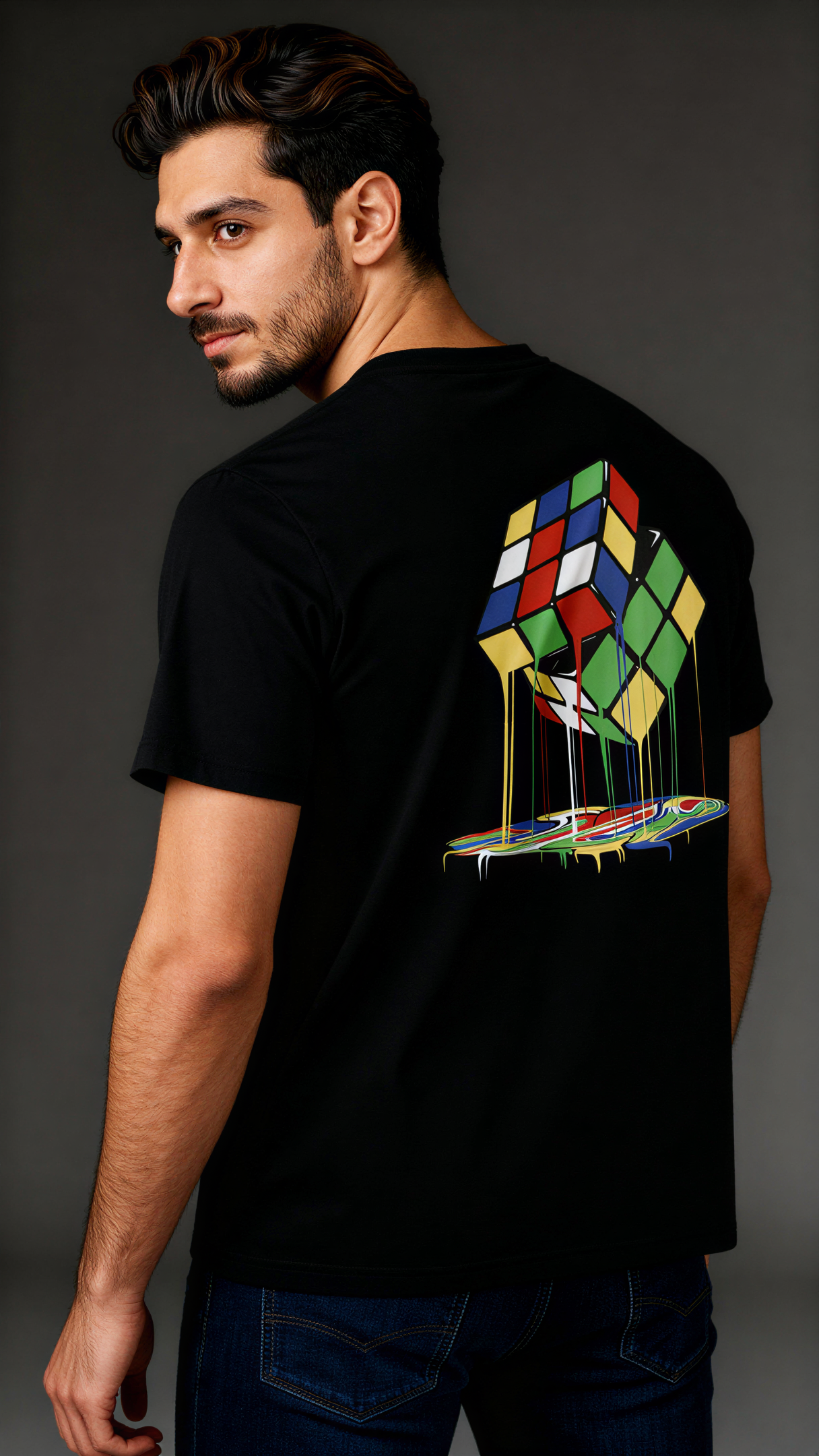 במבט מאחור, גבר לובש חולצת כותנה אורגנית שחורה עם הדפס צבעוני של קוביית רוביק נמסה מבית פיורלום.