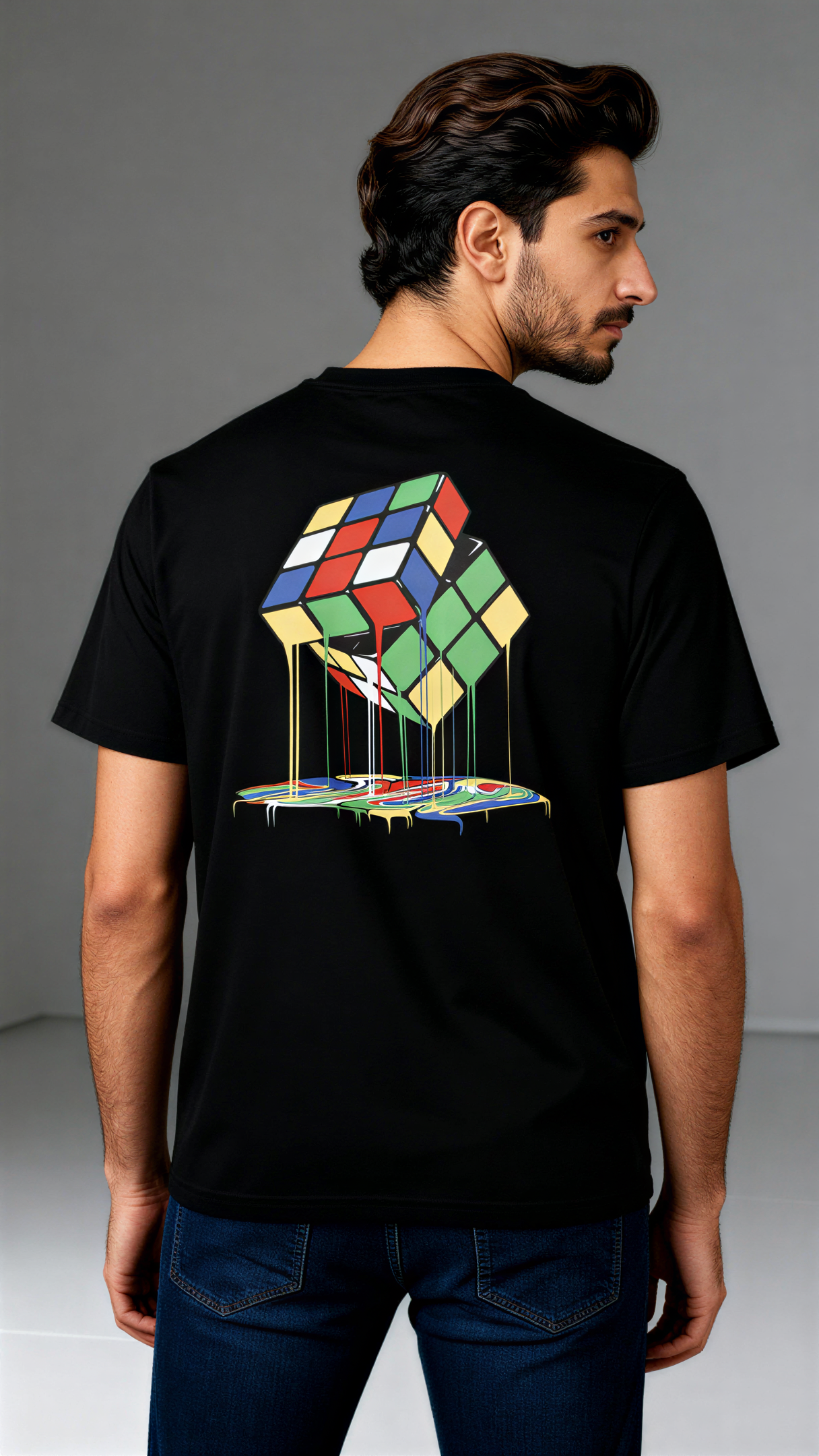 במבט מאחור, גבר לובש חולצת כותנה אורגנית שחורה עם הדפס צבעוני של קוביית רוביק נמסה מבית פיורלום.