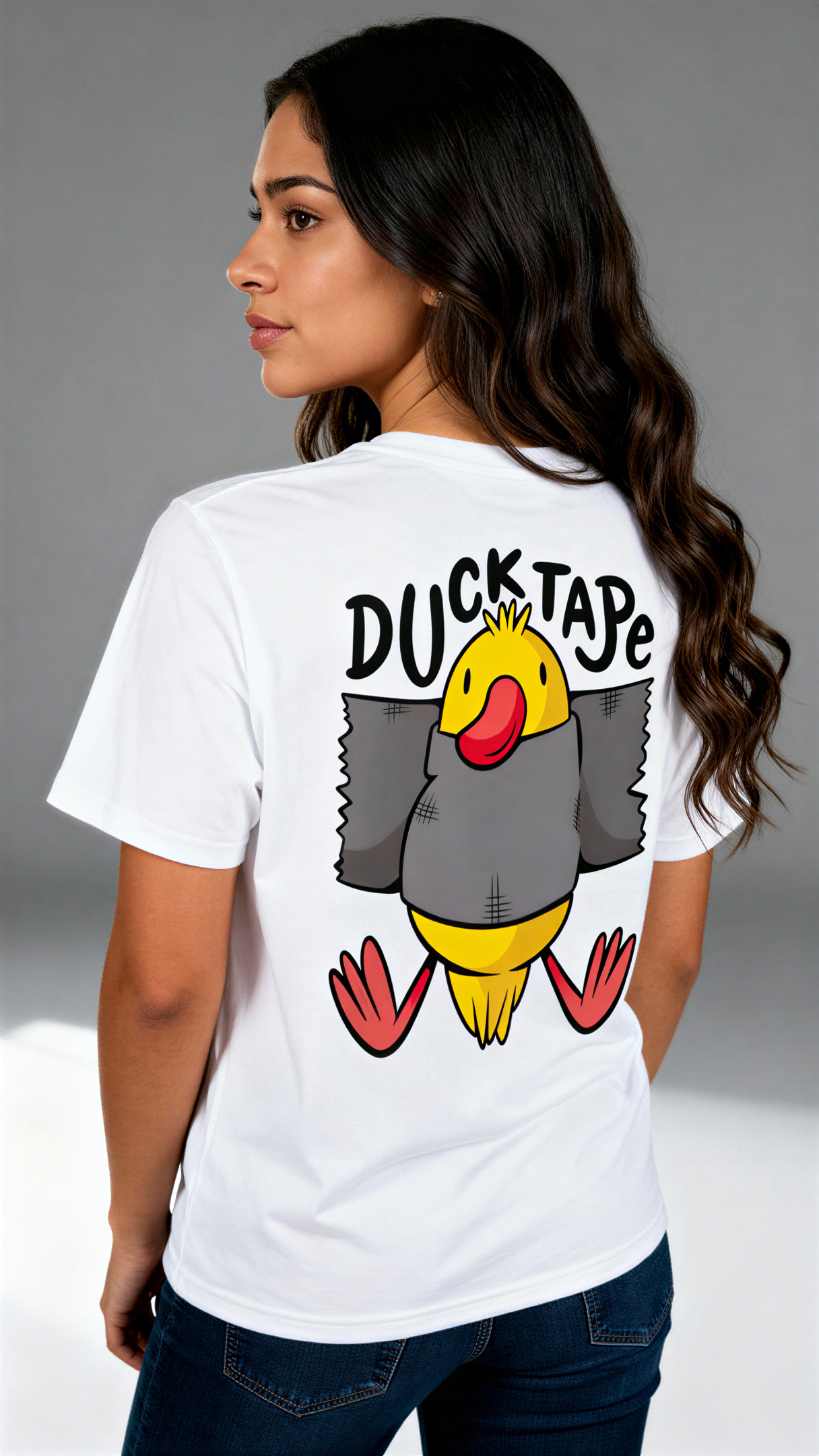 במבט מאחור, אישה לובשת חולצת כותנה אורגנית לבנה עם הדפס צבעוני של ברווז עטוף בנייר דבק וכיתוב "Duck Tape" מבית פיורלום.