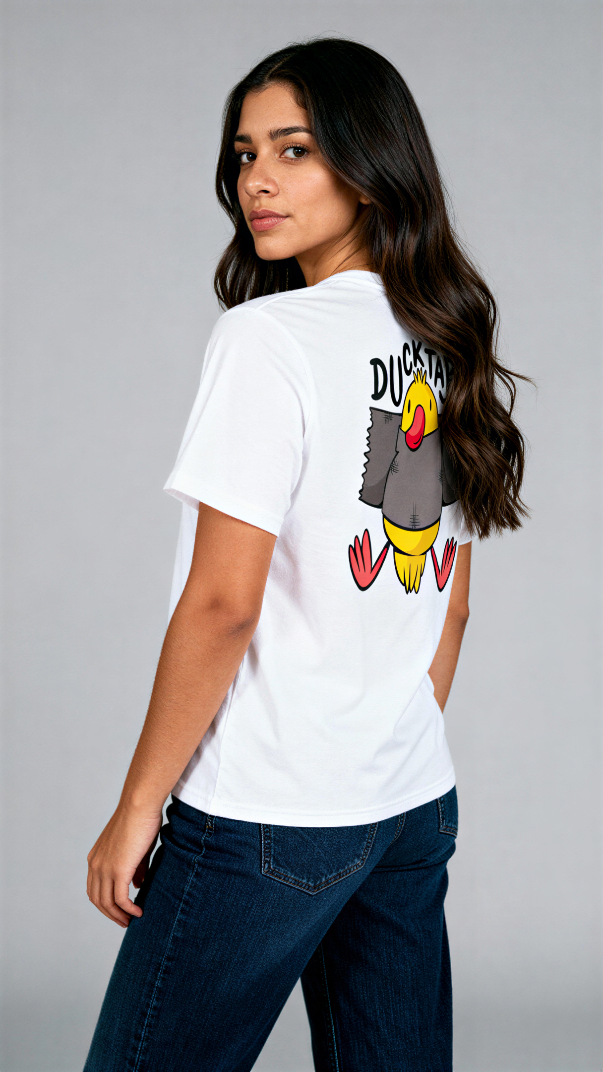 במבט צדדי, אישה לובשת חולצת כותנה אורגנית לבנה עם הדפס צבעוני של ברווז עטוף בנייר דבק וכיתוב "Duck Tape" מבית פיורלום.