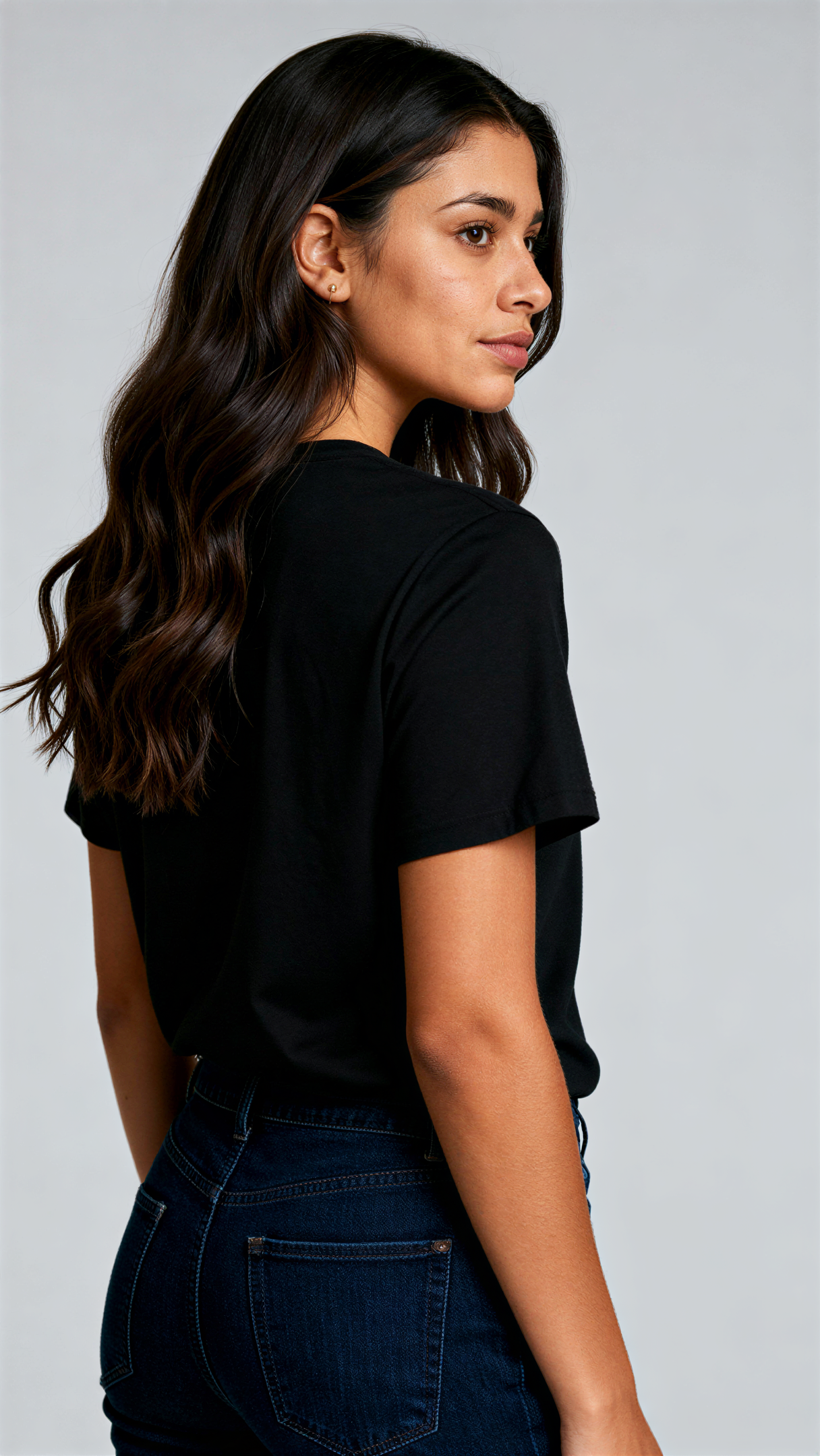 במבט מאחור, אישה לובשת חולצת כותנה אורגנית שחורה חלקה מבית פיורלום.